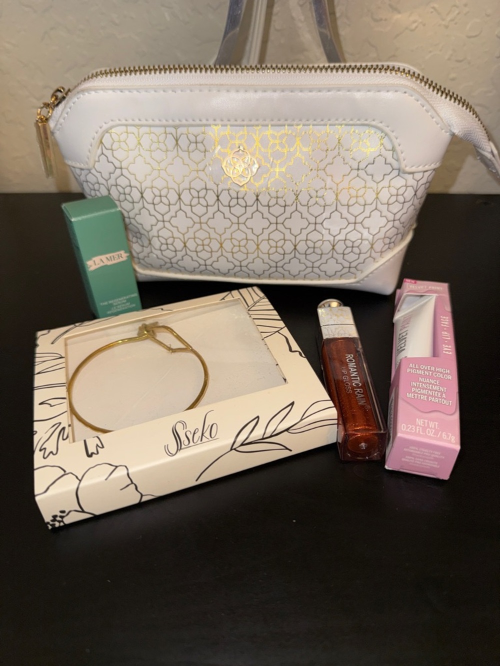 Kendra Scott Cosmetic Bag. LA MER Serum. Lip Gloss. Hard Candy. Sseko bracelet